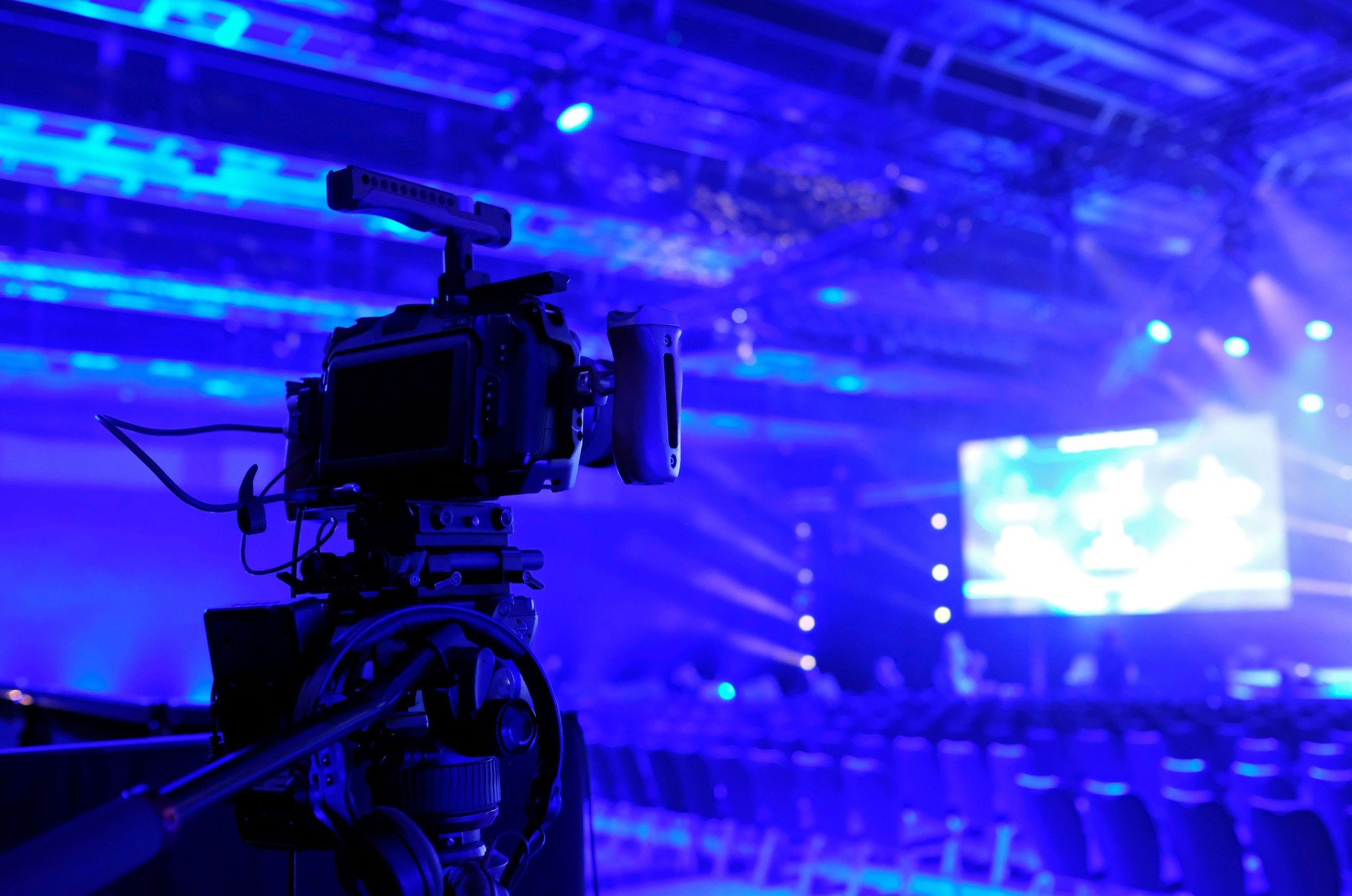 Camera pointed at the stage during an event in a darkened room